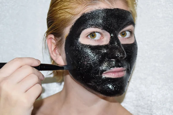 Дівчина в косметичній чорній масці. Маска для очищення аспірину та активованого вугілля. Чорна косметична маска для обличчя . — стокове фото