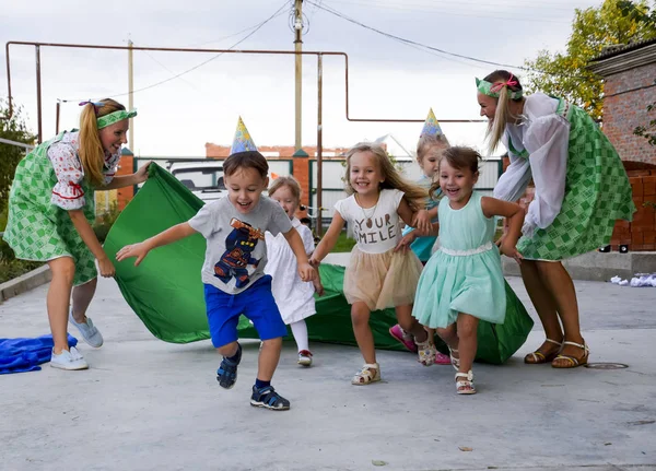 Ocio de los niños preescolares. Animadores en una fiesta infantil. Actuar y desarrollar juegos para niños . — Foto de Stock