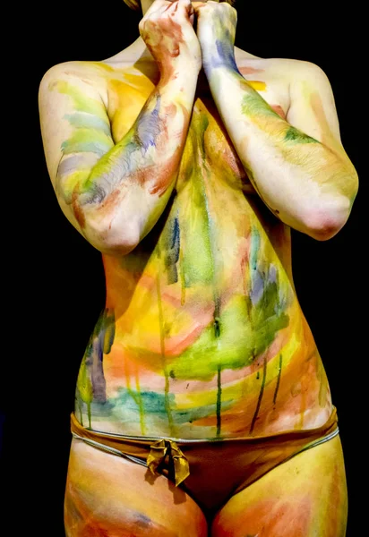 Body art. Drawing on the body. Beautiful girl with painted body watercolors. A white young girl painted the body with paint