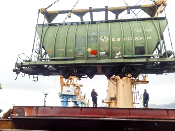 Transporte de vagones de mercancías en el puerto por una grúa portuaria. Operaciones de elevación de carga. Puerto industrial — Foto de Stock