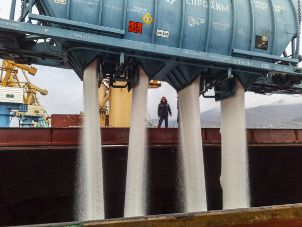 Novorossiysk, Russia - August 11, 2017: spillage of saltpeter from the car into the hold of the tanker. Loading of mineral fertilizers in the ships hold.
