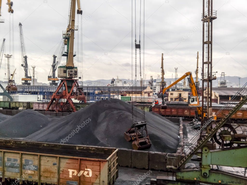 Cargo industrial port, port cranes. Loading of anthracite. Transportation of coal. Heap of coal