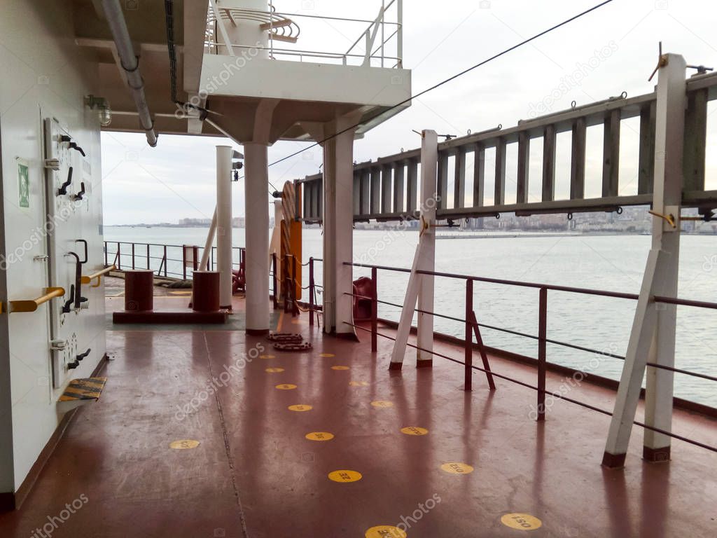 The deck of a cargo ship. Red floor and white walls