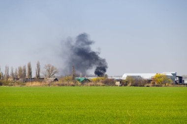 Yangın ve siyah duman köyün dışında. Yanan kurum.