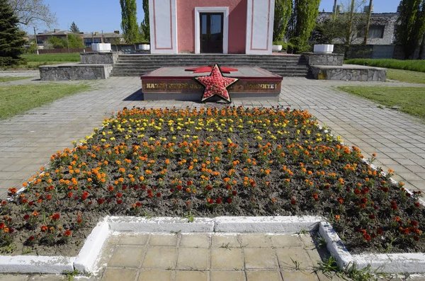 Cappella e stella con fuoco eterno vicino alla casa della cultura vicino alla piazza centrale nell'insediamento Oktyabrsky . — Foto Stock