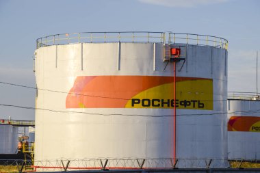Rezervuarlar Rosneft yağ depo yakıt ile. Batan güneşin ışığında tankları.
