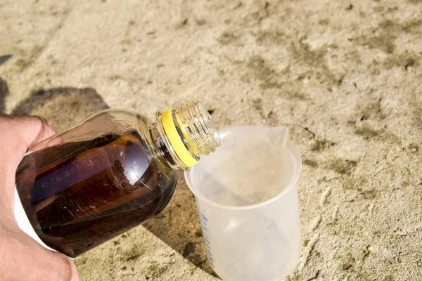 Pouring thick glyphosate solution in a beaker — Stock Photo, Image