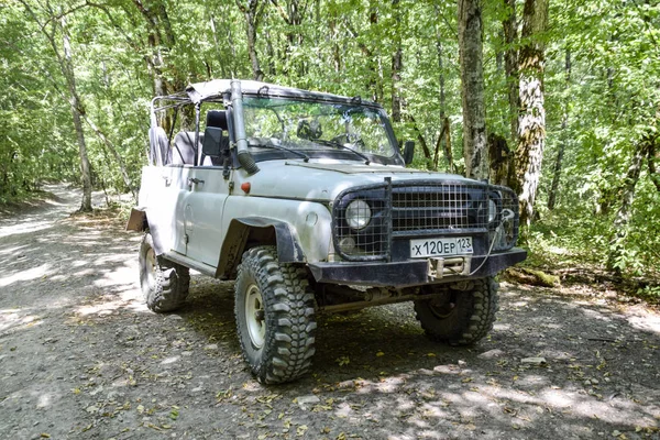 SUV en el bosque. Transporte para terrenos montañosos y montañosos. Vehículo todoterreno ruso . — Foto de Stock