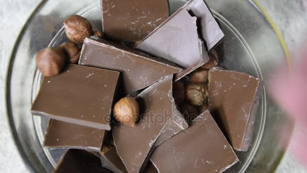 Chocolat au lait et noisettes dans une tasse en verre . — Video