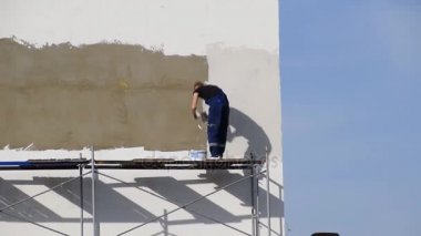Harç inşaatçılar ticari bir binanın duvarında sıvalı. Wor