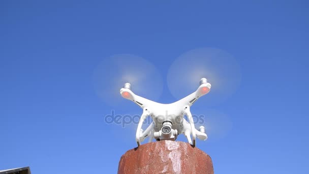 Robot DJI Phantom 4. Biaya drone pada dukungan merah dan mempersiapkan untuk take-off. Robot dengan latar belakang putih . — Stok Video