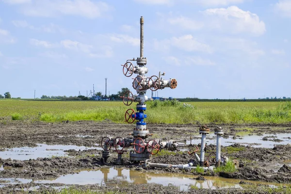 Oil well after repair in mud and puddles.