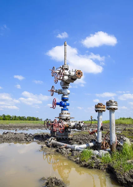 Oil well after repair in mud and puddles.