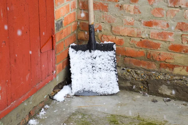 En snöskyffel i snö och står i hörnet — Stockfoto