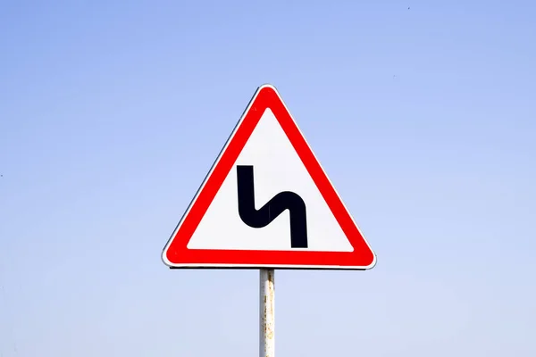 Verkehrszeichen gefährliches Abbiegen. Warnzeichen. — Stockfoto