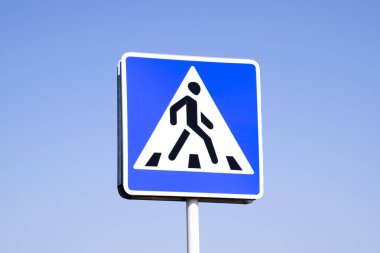 A pedestrian crossing sign. Sign on a blue sky background. clipart