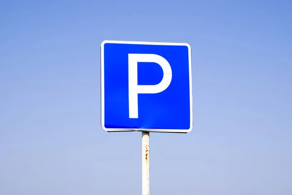 Estacionamento com sinal de estrada. Assine em um fundo azul céu . — Fotografia de Stock