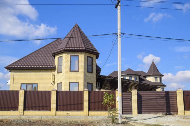 Dekoratif metal bir tuğla ev çatısında. Oluklu metal çit yapılmış.