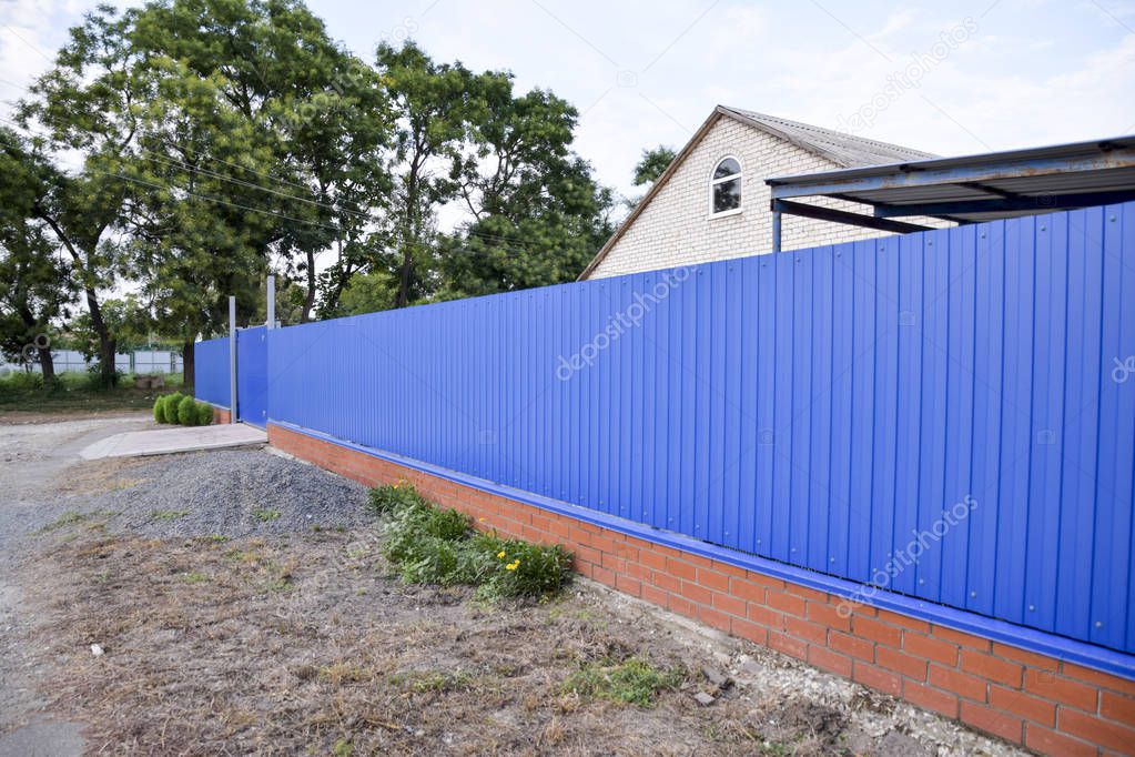 Fence and gate from sheets of blue corrugated metal