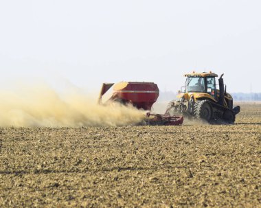 Rusya, Temryuk - 19 Temmuz 2015: Traktör sürmek sahada ve toprağa gübre yapar. Kuru toprak traktör römork toz bulutları. Tarlayı sonra gübre.