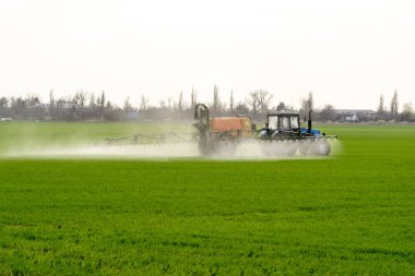 Traktör ince dağınık gübre için bir sprey cihazı ile.
