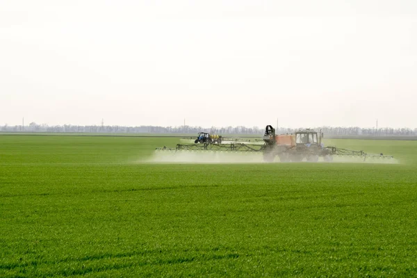 Tractor con un dispositivo de pulverización para fertilizante finamente disperso . — Foto de Stock