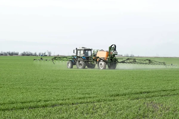 Tractor con un dispositivo de pulverización para fertilizante finamente disperso . — Foto de Stock