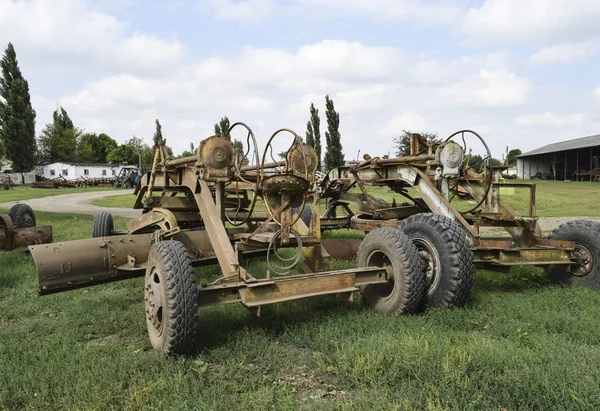 Grader on a trailer for heavy equipment. Trailer Hitch for tractors and combines. Trailers for agricultural machinery.