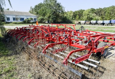 Russia, Temryuk - 15 July 2015: Soil disintegrator, deep loosener on the trailer. Trailer Hitch for tractors and combines. Trailers for agricultural machinery. clipart