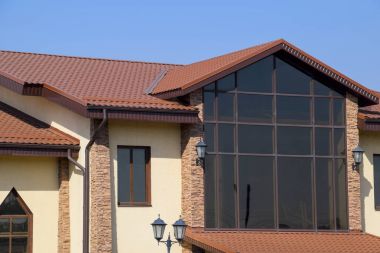 Sarı duvarlar ve kırmızı-kahverengi çatı ile inşa. Kaplama ve çatı kaplama modern malzemeler.