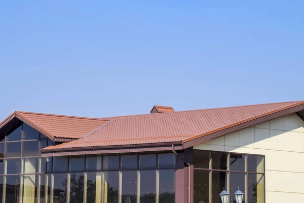 Edificio con paredes amarillas y un techo rojo-marrón. Materiales modernos de acabado y techado . — Foto de Stock