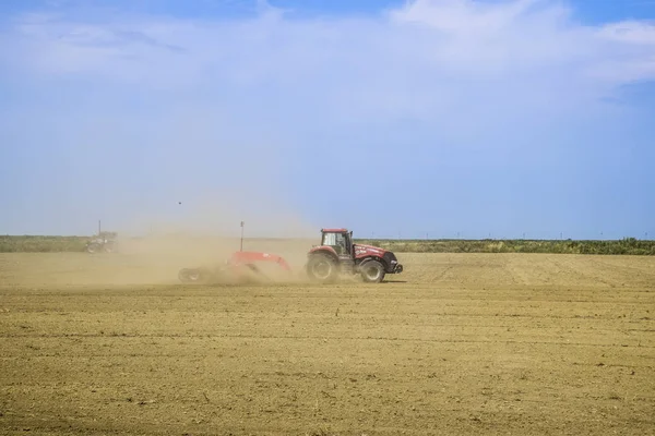 Traktor, egy földgyalu igazítja a talaj, a pályán. A traktor emelt por. — Stock Fotó