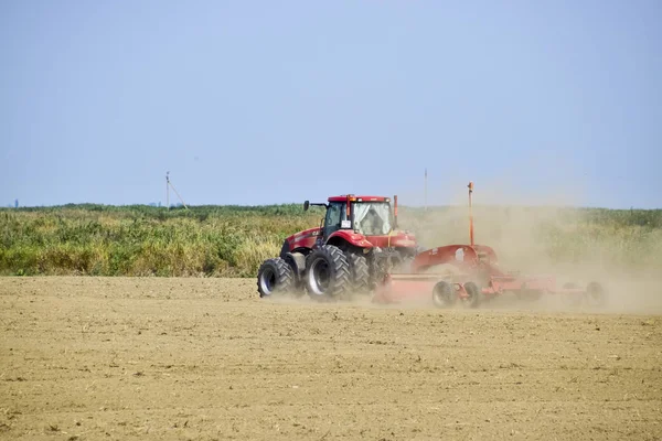 Traktor, egy földgyalu igazítja a talaj, a pályán. A traktor emelt por. — Stock Fotó