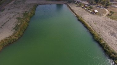 Balık tutmak için yapay bir göl. Göldeki balıkçılar için bir köprü. Gölde balık.