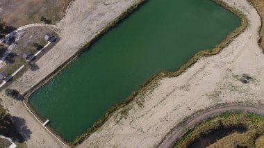 Balık tutmak için yapay bir göl. Göldeki balıkçılar için bir köprü. Gölde balık.