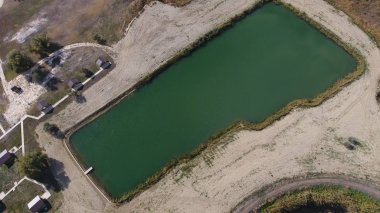 Balık tutmak için yapay bir göl. Göldeki balıkçılar için bir köprü. Gölde balık.