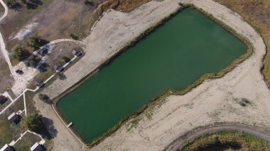 Balık tutmak için yapay bir göl. Göldeki balıkçılar için bir köprü. Gölde balık.