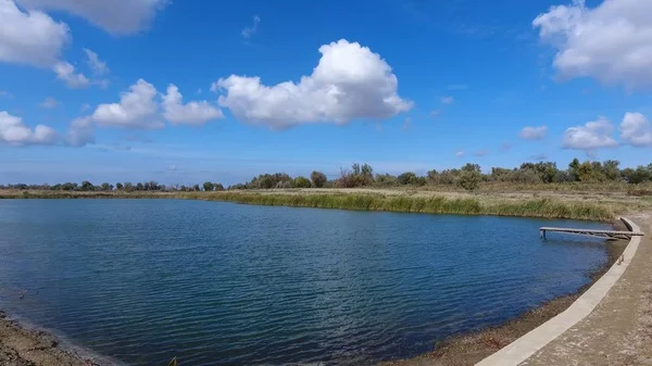 Un lago artificial para la pesca. Un puente para pescadores en el lago. Pesca en lago . — Foto de Stock