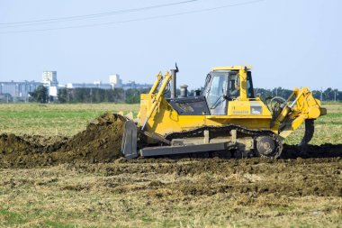 Rusya, Temryuk - 15 Temmuz 2015: zemin tesviye sarı traktör ile ekli grederom yapar. Drenaj sistemi alanında çalışmak.