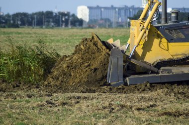 Zemin tesviye sarı traktör ile ekli grederom yapar.