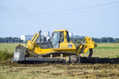Zemin tesviye sarı traktör ile ekli grederom yapar.