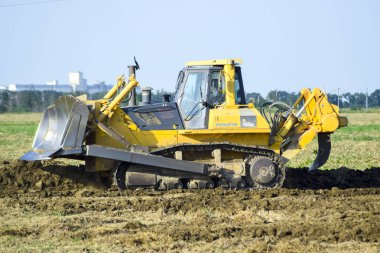 Zemin tesviye sarı traktör ile ekli grederom yapar.
