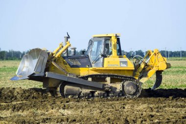 Zemin tesviye sarı traktör ile ekli grederom yapar.