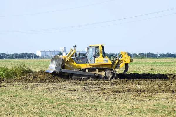 Zemin tesviye sarı traktör ile ekli grederom yapar.