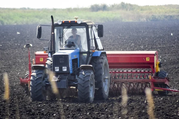 Traktor és a vetőgép területén. magok a talaj vetés. — Stock Fotó