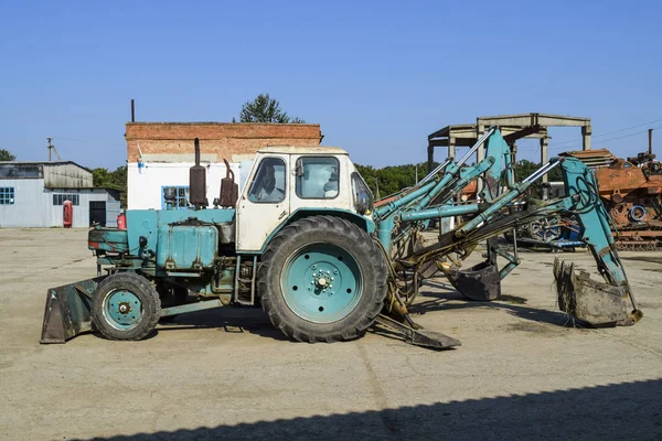 Tractor con cubo para cavar tierra. Bulldozer y niveladora . — Foto de Stock