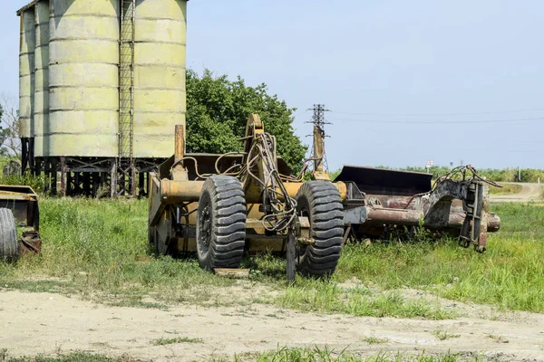 Grader on a trailer for heavy equipment. Trailer Hitch for tractors and combines. Trailers for agricultural machinery.