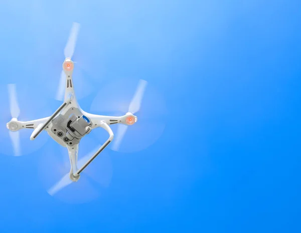 Drone DJI Phantom 4 in flight. Quadrocopter against the blue sky — Stock Photo, Image