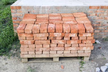 Kırmızı tuğlalı ev temeli üzerine düzgünce katlanmış. Ev inşaatı.