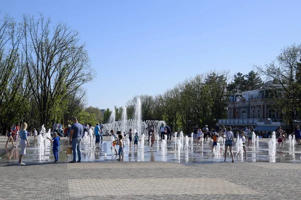 De fontein van de stad in de stad van Krasnodar. Mensen lopen door de fontein. Water spatten. — Stockfoto